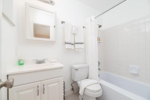 uma casa de banho branca com um WC e um lavatório em The Retreat 2 - Wilton Manors em Fort Lauderdale