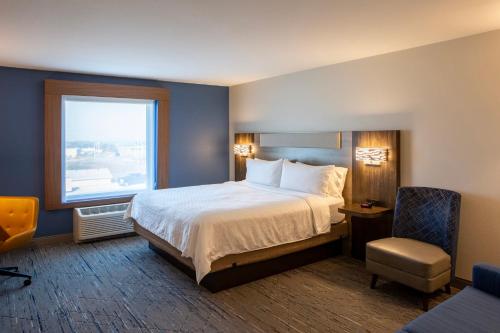 a hotel room with a bed and a window at Holiday Inn Express & Suites Sioux City-South by IHG in Sioux City