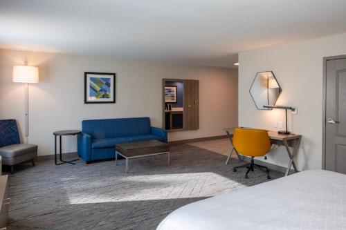 a hotel room with a bed and a desk and chairs at Holiday Inn Express & Suites Sioux City-South, an IHG Hotel in Sioux City