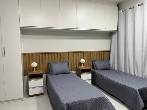 zwei Betten in einem Zimmer mit zwei Lampen auf Tischen in der Unterkunft Apartamento no Condominio da Fé - Canção Nova in Cachoeira Paulista