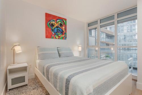 un dormitorio blanco con una pintura de perro en la pared en Cozy 2BR Close to CN Tower & Harbourfront en Toronto
