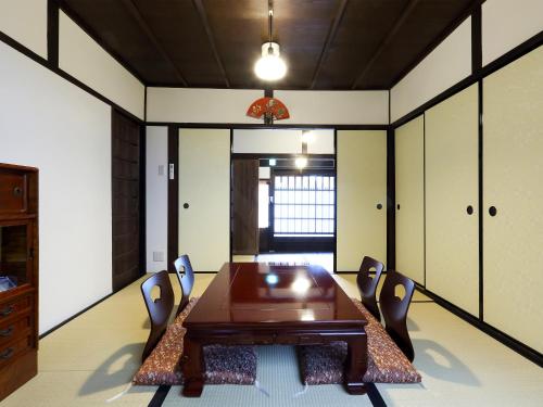 a dining room with a wooden table and chairs at 京町家お宿・花 in Kyoto