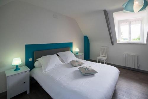 - une chambre avec un lit blanc et 2 oreillers dans l'établissement Le ruset, à Saint-Donan