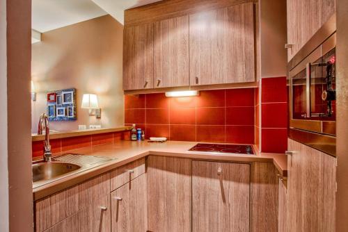 une cuisine avec des armoires en bois et un évier dans l'établissement Le City - Parking and comfort in the city centre, à Caen