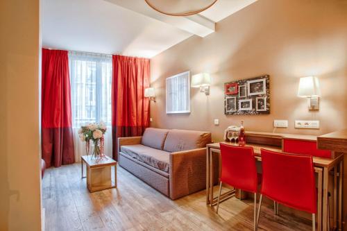- un salon avec un canapé et une table avec des chaises rouges dans l'établissement Le City - Parking and comfort in the city centre, à Caen