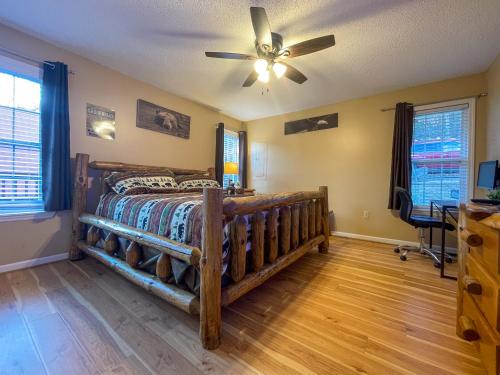 a bedroom with a wooden bed and a ceiling fan at Heavenly View - Bear Themed Cabin, HotTub, Dog-Friendly, Near Gatlinburg in Gatlinburg