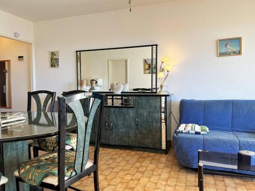 un salon avec un canapé bleu et un miroir dans l'établissement Appartement 2 pièces, 4 couchages - Terrasse, parking, proche plage - Le Lavandou - FR-1-251-543, au Lavandou