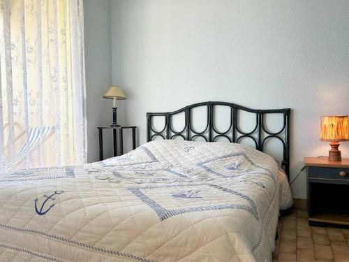 une chambre avec un lit avec une couverture bleue et blanche dans l'établissement Appartement 2 pièces, 4 couchages - Terrasse, parking, proche plage - Le Lavandou - FR-1-251-543, au Lavandou