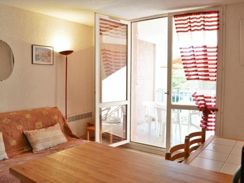 d'un salon avec une table et un balcon. dans l'établissement Appartement 2 pièces, terrasse, parking privé, proche plage, 6 couchages - Le Lavandou - FR-1-251-547, au Lavandou