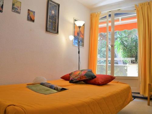 - une chambre avec un grand lit orange et une fenêtre dans l'établissement Appartement 2P 4 Couchages avec Balcon et Garage - Proche Plage et Commerces - FR-1-251-520, à Bormes-les-Mimosas