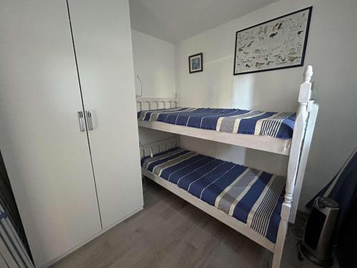 Ce dortoir comprend 2 lits superposés et un placard. dans l'établissement Deux Pièces avec Terrasse, Cour Privée et Piscine - Le Grau-du-Roi - FR-1-250-264, au Grau-du-Roi