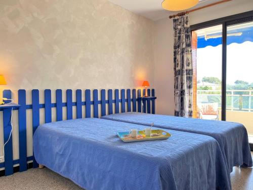 - un lit bleu avec un plateau de nourriture dans l'établissement Charmant T2 avec terrasse, clim et garage à Bormes-les-Mimosas, 2 piscines, proche plage et calme - FR-1-251-542, à Bormes-les-Mimosas