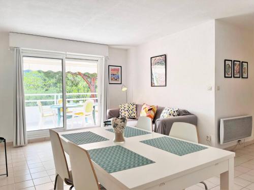 un salon avec une table et un canapé dans l'établissement Appartement en bord de mer avec terrasse, 3 pièces, 4 couchages, parking privé au Lavandou - FR-1-251-555, au Lavandou