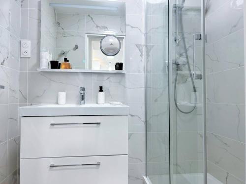 uma casa de banho branca com um lavatório e um chuveiro em Appartement Bormes-les-Mimosas, 3 pièces, 5 personnes - FR-1-251-575 em Bormes-les-Mimosas