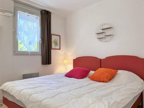 une chambre avec un lit avec deux oreillers dessus dans l'établissement Appartement Vacances - 4 Pers, Piscine, Terrasse, Proche Plage au Lavandou - FR-1-251-556, au Lavandou