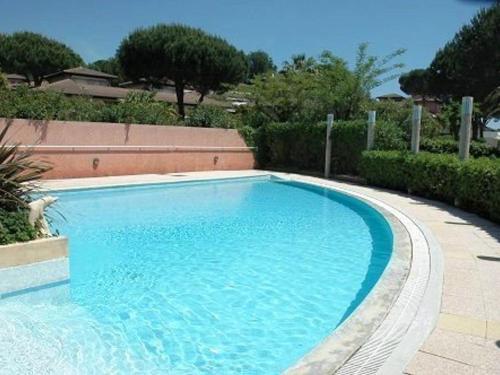 une grande piscine bleue dans une cour dans l'établissement Appartement Vacances - 4 Pers, Piscine, Terrasse, Proche Plage au Lavandou - FR-1-251-556, au Lavandou