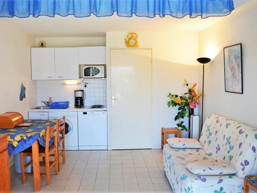 un salon avec une table et une cuisine dans l'établissement Appartement Duplex 6 Pers, 100m Plage, Terrasse Ensoleillée, Parking Privé, Proche Commerces - FR-1-251-564, au Lavandou