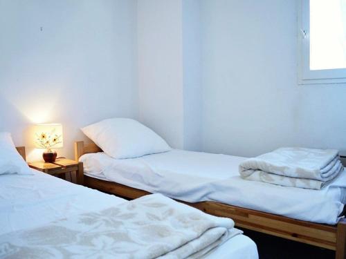 - 2 lits jumeaux dans une chambre avec une lampe dans l'établissement Appartement Duplex 6 Pers, 100m Plage, Terrasse Ensoleillée, Parking Privé, Proche Commerces - FR-1-251-564, au Lavandou