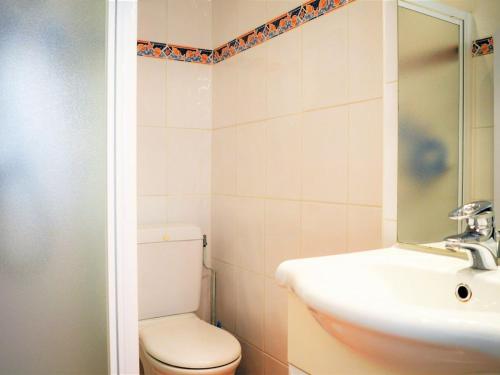 une salle de bain avec toilettes, lavabo et miroir dans l'établissement Appartement 2P avec terrasse, jardin et piscine - Le Lavandou, 4 couchages, parking inclus - FR-1-251-573, au Lavandou