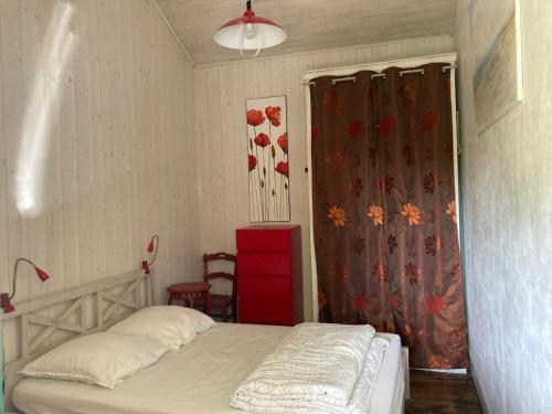 - une petite chambre avec un lit et un rideau dans l'établissement Maison de Charme pour 6 à Biscarrosse-Plage, Proche Centre, Jardin, BBQ, Non-Fumeur, Animaux Non Admis - FR-1-521-229, à Biscarrosse