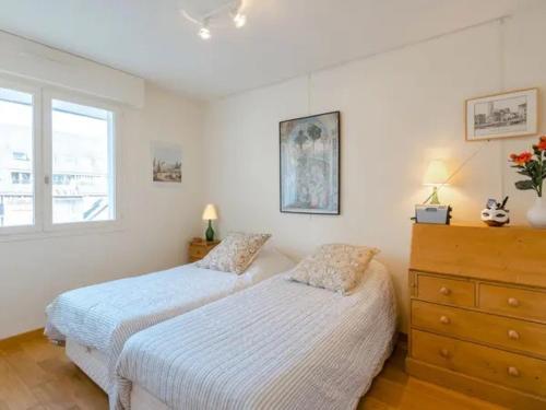 - 2 lits dans une chambre avec une commode et une fenêtre dans l'établissement Bel appartement 2 pièces avec balcon, à 2 min de la gare - FR-1-712-75, à Deauville