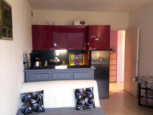 - une cuisine avec des placards rouges et un réfrigérateur noir dans l'établissement Appartement 2 pièces cabine - 6 pers., 45m², Balcon de Villard, au pied des pistes - FR-1-689-130, à Villard-de-Lans