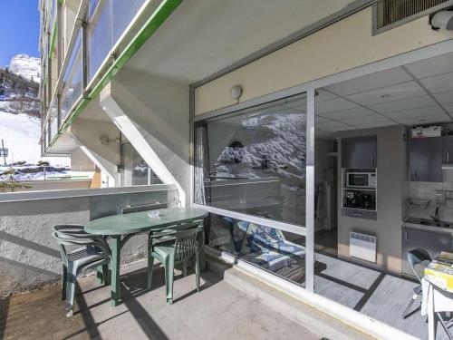 un balcon avec une table, des chaises et une fenêtre dans l'établissement Appartement 4 pers., pied de piste, terrasse, centre Gourette - FR-1-400-125, à Eaux-Bonnes