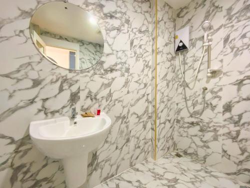 Baño blanco con lavabo y espejo en Goldsmith Bangkok Residence, en Bangkok