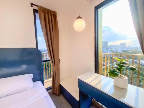 Un dormitorio con una cama y una ventana con una planta en Goldsmith Bangkok Residence, en Bangkok