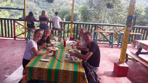 a group of people sitting at a table eating food at CARIBbEAN Paradise Hotel in Lanquín