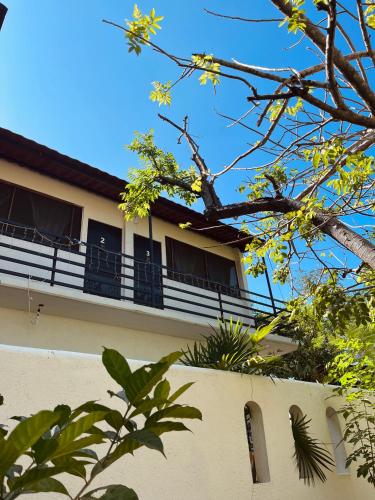 a building with a balcony and a tree at Coco Viejo Posada in San Pedro Pochutla