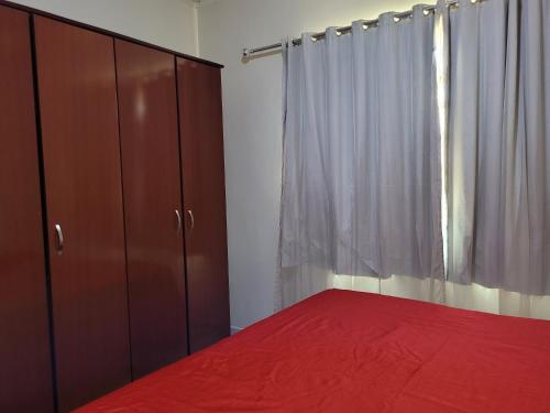 um quarto com uma cama vermelha e uma janela em Casa espaçosa com linda piscina em Porto Velho