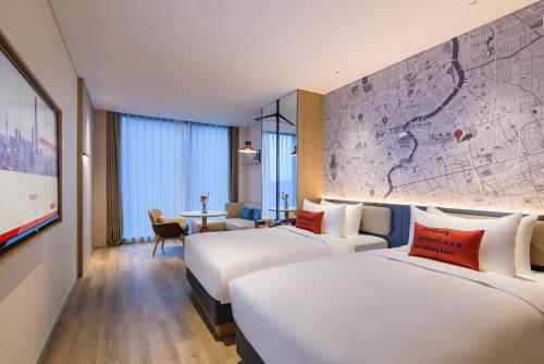two beds in a hotel room with a map on the wall at IntercityHotel Shanghai New International Expo Center in Shanghai