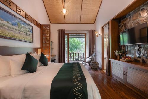 a bedroom with a large bed with a flat screen tv at Mai Chau Mountain View Resort in Mai Chau