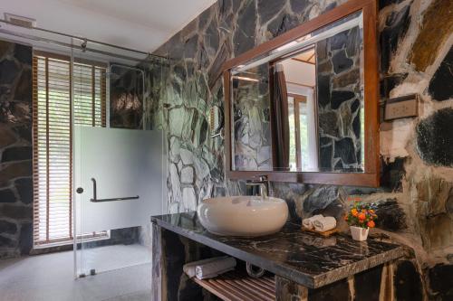 a bathroom with a sink and a stone wall at Mai Chau Mountain View Resort in Mai Chau