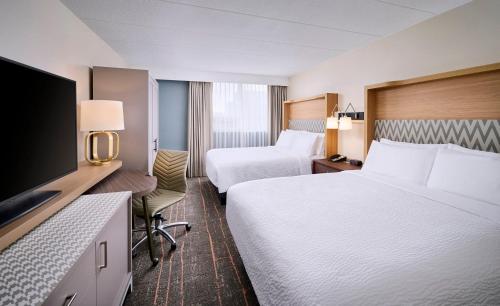 Habitación de hotel con 2 camas y TV de pantalla plana. en Holiday Inn Burlington Hotel & Conference Centre, an IHG Hotel, en Burlington