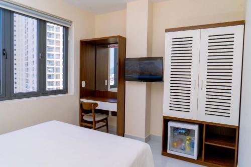 1 dormitorio con 1 cama, TV y escritorio en Hai Duong Vung Tau Hotel - Khách sạn Hải Dương Vũng Tàu en Vung Tau