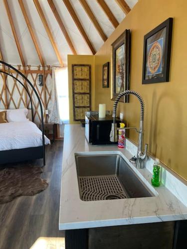 a kitchen with a sink and a bed in a room at The Lotus Yurt at Nomad Yurts, Lake Powell in Big Water