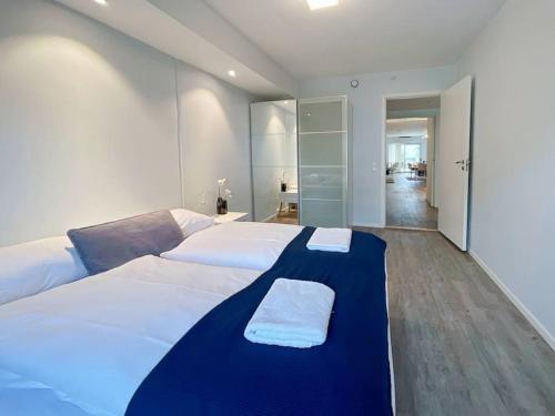 a bedroom with a large bed with a blue blanket on it at Unique Place by Stavanger BnB 19 (2BR, Terrace, Parking/Airport Shuttle) in Stavanger