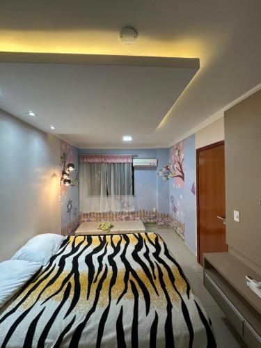 Habitación con cama con estampado de cebra. en Flat Cézar's Park, en Caldas Novas