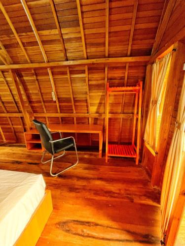 a room with a bed and a chair in it at ANARA VILLA SAMOSIR MANAGED BY 3 SMART HOTEL in Sinapuran
