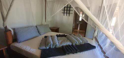 Bett mit gestreiften Kissen auf einem Zimmer in der Unterkunft Bonito Bay in Cabo Nhabacal