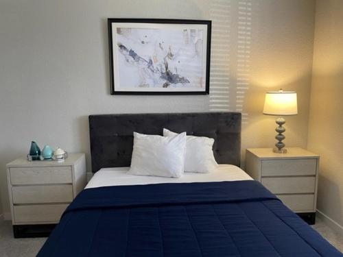 a bedroom with a blue and white bed and a lamp at Stylish Modern 3bd-2ba With Amenities in Daytona Beach
