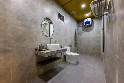 uma casa de banho com um lavatório e um WC em Tropical retreat Homestay em Ilha de Cát Bà