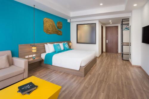 um quarto de hotel com uma cama e um sofá em Khách Sạn X2 Vibe Việt Trì em Làng Tiên Cát