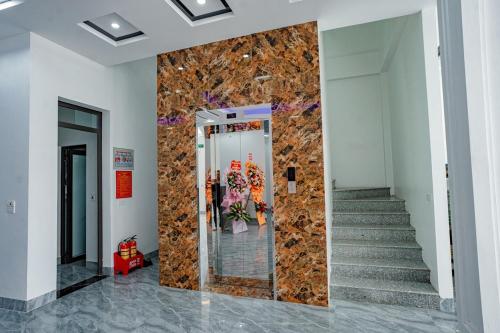 a lobby with a stone wall and stairs at Khách Sạn HƯƠNG HANA in Phúc Trì