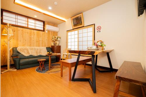 uma sala de estar com uma mesa e um sofá em 一戸建民泊 Tokyo St-ar House 東京星宿 em Tóquio