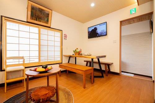 uma sala de estar com duas mesas e uma janela em 一戸建民泊 Tokyo St-ar House 東京星宿 em Tóquio
