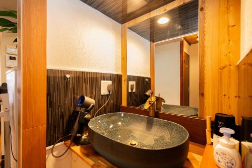 a bathroom with a large black tub in front of a mirror at 一戸建民泊 Tokyo St-ar House 東京星宿 in Tokyo