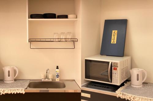 a microwave oven with a box on top of it at Mitomi Home 4F in Tokyo